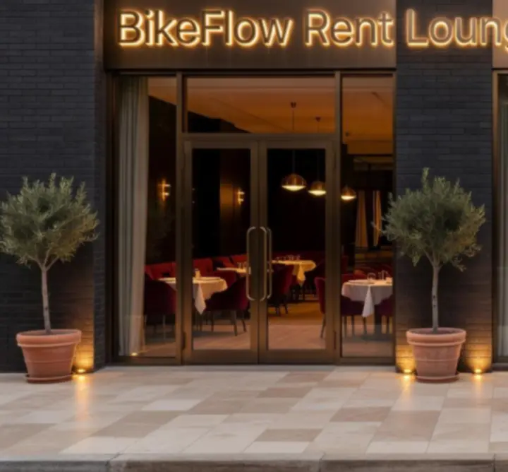 A BikeFlow Rent Lounge esti, kivilágított homlokzata prémium hangulattal.